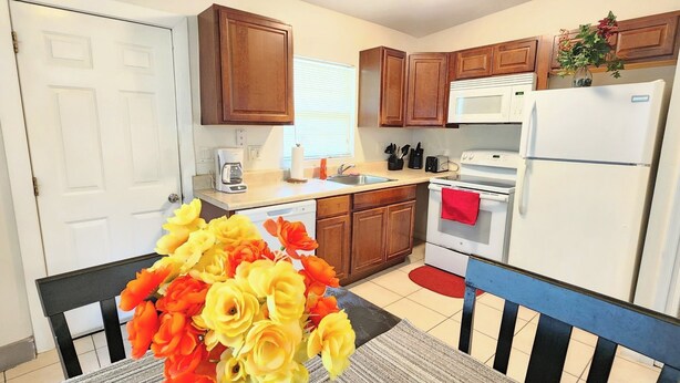 A kitchen with wooden cabinets, a microwave, a stove, and a refrigerator.