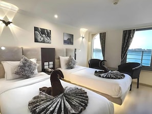 Une chambre double avec deux lits, une vue sur la mer et un panneau indiquant qu'il s'agit d'une chambre double.