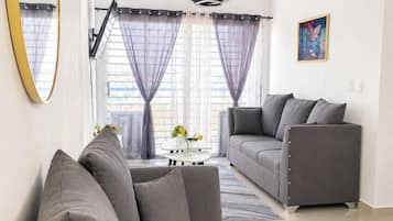 Una sala de estar moderna con un sofá gris, una mesa de centro y un cuadro en la pared.