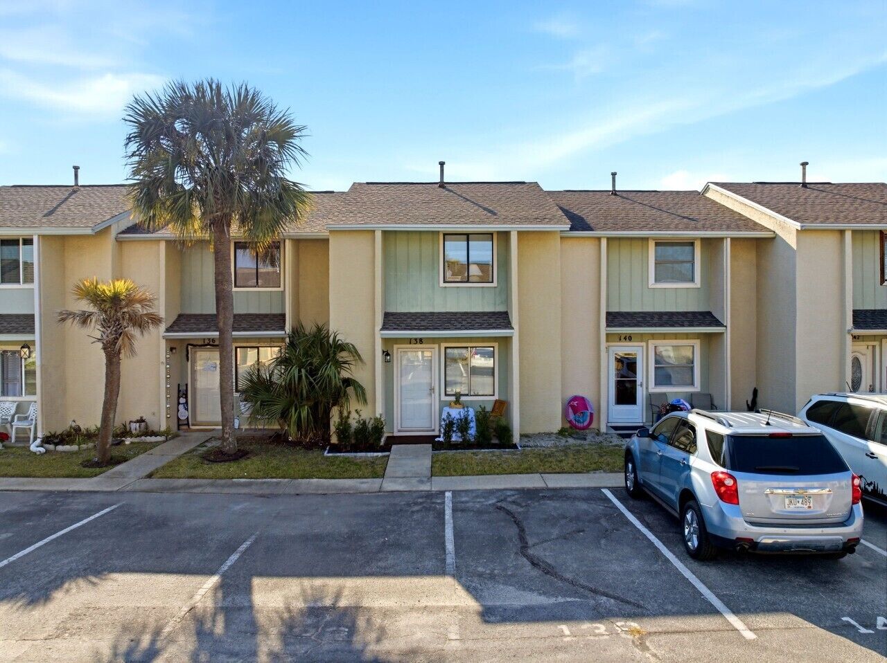 A row of townhouses with a parking lot in front.