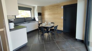 Een moderne keuken met een eethoek, een raam en een deur.