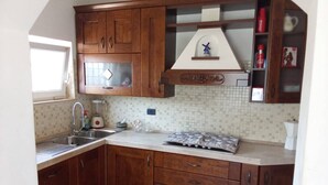 A kitchen with wooden cabinets, a sink, a window, and a tiled backsplash.