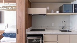 A compact kitchen with a microwave, sink, and a built-in oven. - Studio W/city View in Urubici Ust0506 (Urubici)