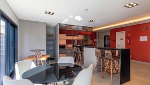 Un intérieur moderne comprenant un espace repas, un bar et une cuisine.