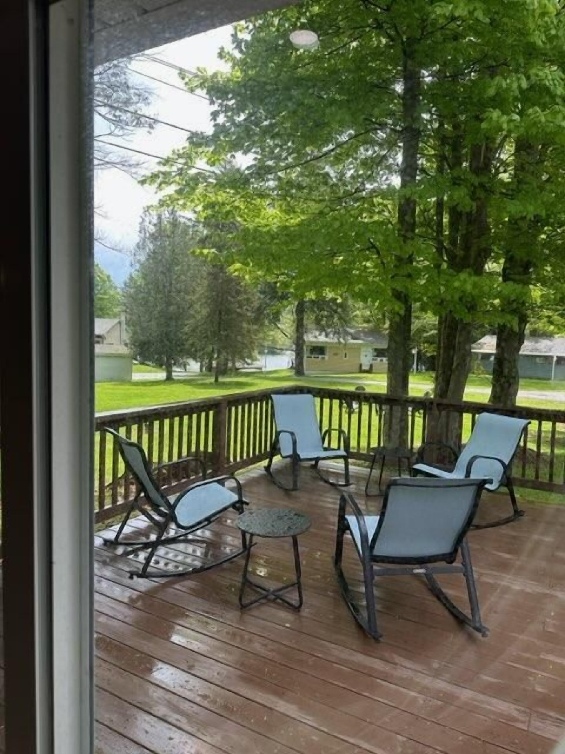A wooden deck with outdoor furniture and a view of a residential area.