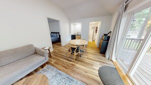 Un espace de vie compact comprenant un canapé, une table à manger et une kitchenette.