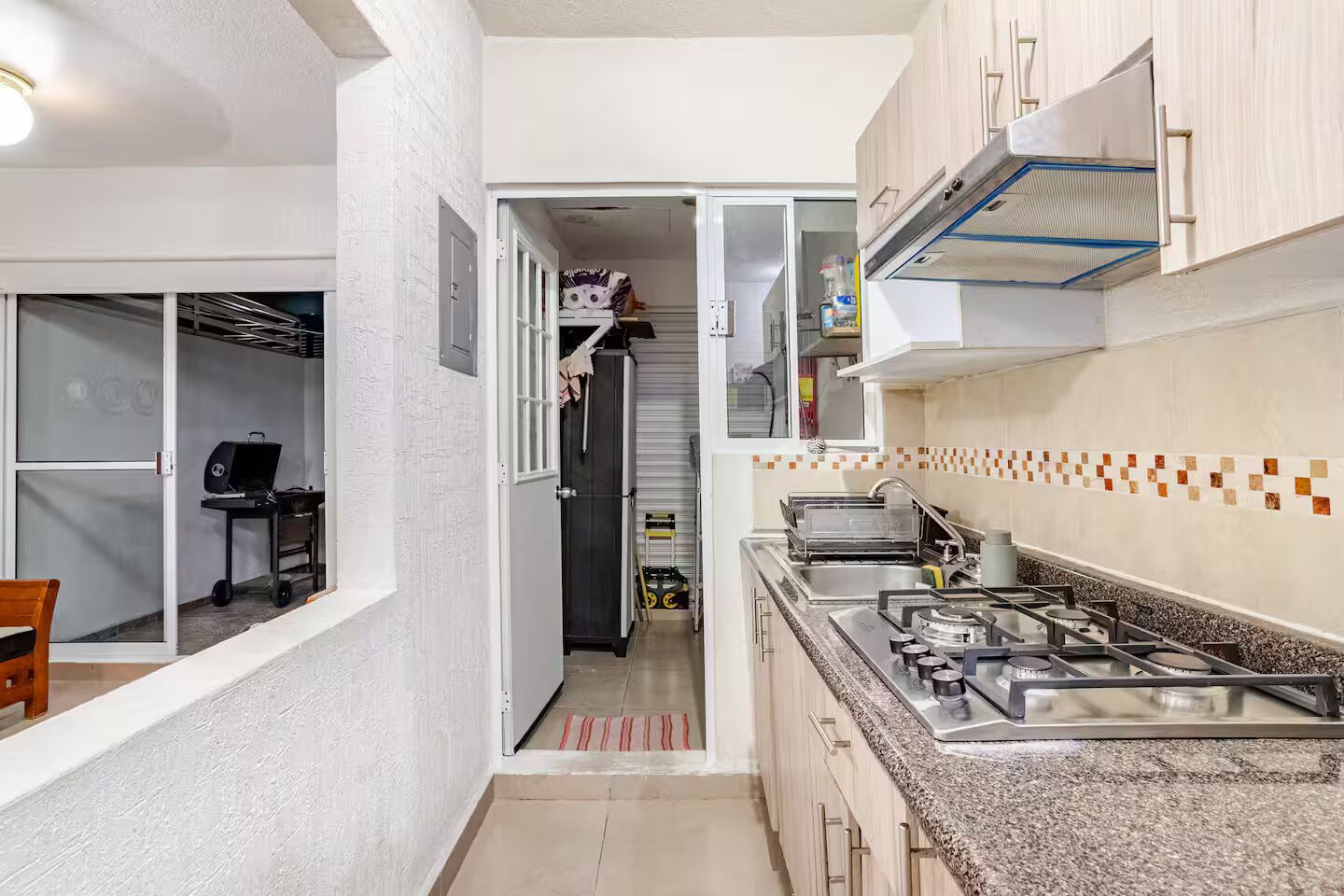A compact kitchen with a gas stove, a sink, and a refrigerator.