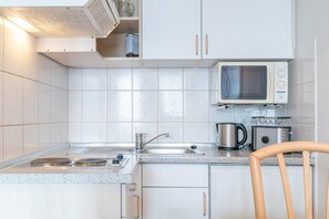 Eine Küche mit Mikrowelle, Toaster, Wasserkocher und Spüle.