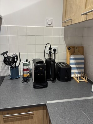 Eine Küche mit Kaffeemaschine, Toaster und Schneidebrett.