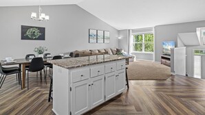 Een moderne keuken met een eethoek, een groot kookeiland en uitzicht op de omgeving.
