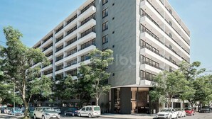 A multi-story hotel with balconies, a parking lot, and trees. - Rbk Dpto GIM-3 personas-Lavanderia-WIFI (Santiago)