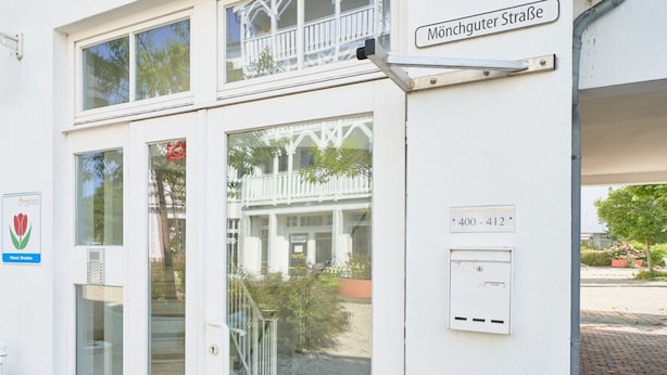 Un bâtiment avec une enseigne indiquant « Mönchguter Straße » et une porte dotée d’un système de verrouillage à clavier.