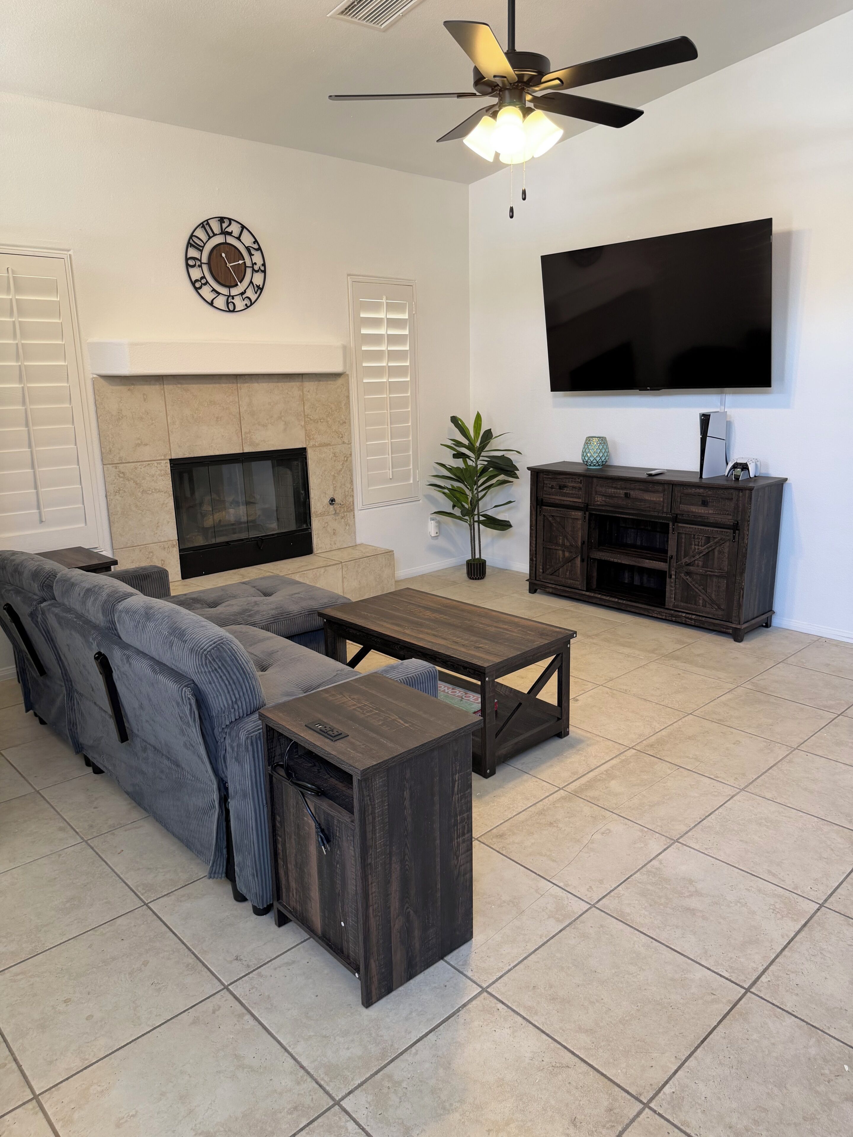 Una sala de estar con un sofá modular, una mesa de centro, una chimenea, un televisor y un mueble bajo para la televisión.