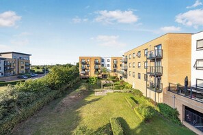 Un immeuble résidentiel doté de nombreux balcons, d’une cour intérieure et d’un espace de stationnement.