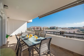 A balcony with a dining table set for four, overlooking a cityscape. - LXR Totally Refurbished Riviera 2-Bedroom (AN)