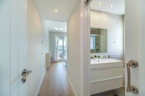 A modern bathroom with a large mirror, a sink, and a walk-in shower. - LXR Totally Refurbished Riviera 2-Bedroom (AN)