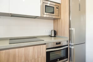 A kitchen with a microwave, oven, and refrigerator. - LXR Totally Refurbished Riviera 2-Bedroom (AN)