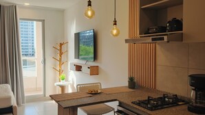 Una cocina moderna con una isla central, luces colgantes y un televisor de pantalla plana.