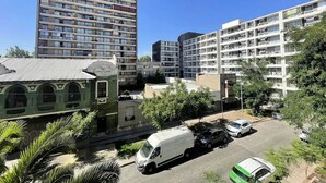 Um edifício residencial com vários andares, varandas, área de estacionamento e um prédio com janelas em arco.