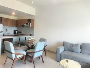 A modern living space with a kitchen, dining area, and seating. - Welcoming 2-bedroom condo with Rooptop in vibrant Bucerías (Bucerías)