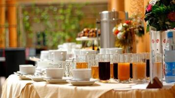 A breakfast buffet table with various beverages and dishes.