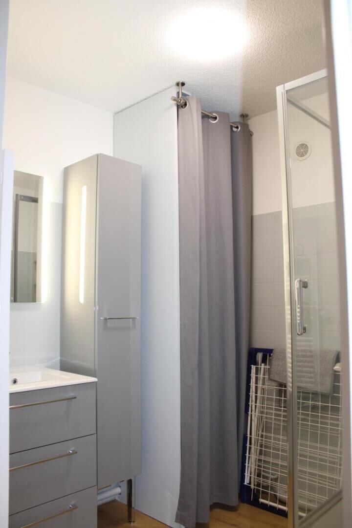 Une salle de bain équipée d’une douche, de toilettes, d’un lavabo et d’un miroir.