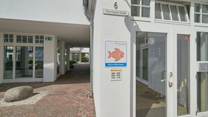 Ein Gebäude mit einem Schild, das 'Mönchgut Straße' und ein Fischsymbol zeigt, was auf einen Ort im Zusammenhang mit Fischerei oder Meeresfrüchten hindeutet.
