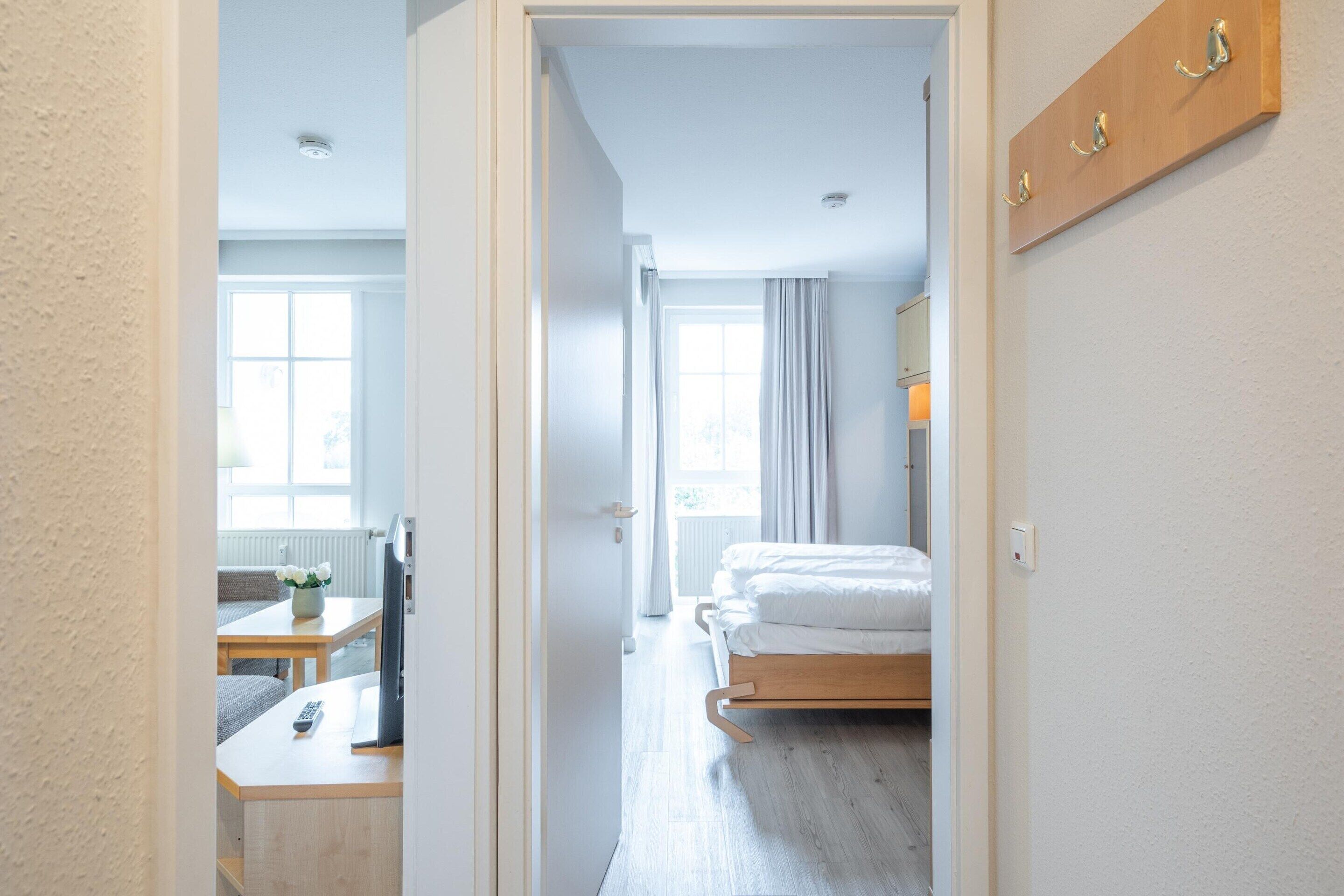 Ein Hotelzimmer mit einem Bett, einem Schreibtisch, einem Stuhl und einem Fenster.