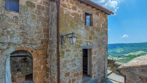 A stone building with a window, a door, and a lantern.