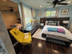 A bedroom with a bed, bedside tables, a chair, a desk, a ceiling fan, and a window with curtains. - Luxury 6 Bedroom Pool Home, Sleeps 14, Water Access and Kayaks (Wilton Manors)