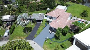 Ein Wohnhaus mit Pool, überdachter Terrasse und großem Rasen.