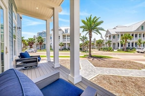 A covered outdoor seating area with a view of a residential street. - Dolce Vita 600 SOU (Port Aransas)