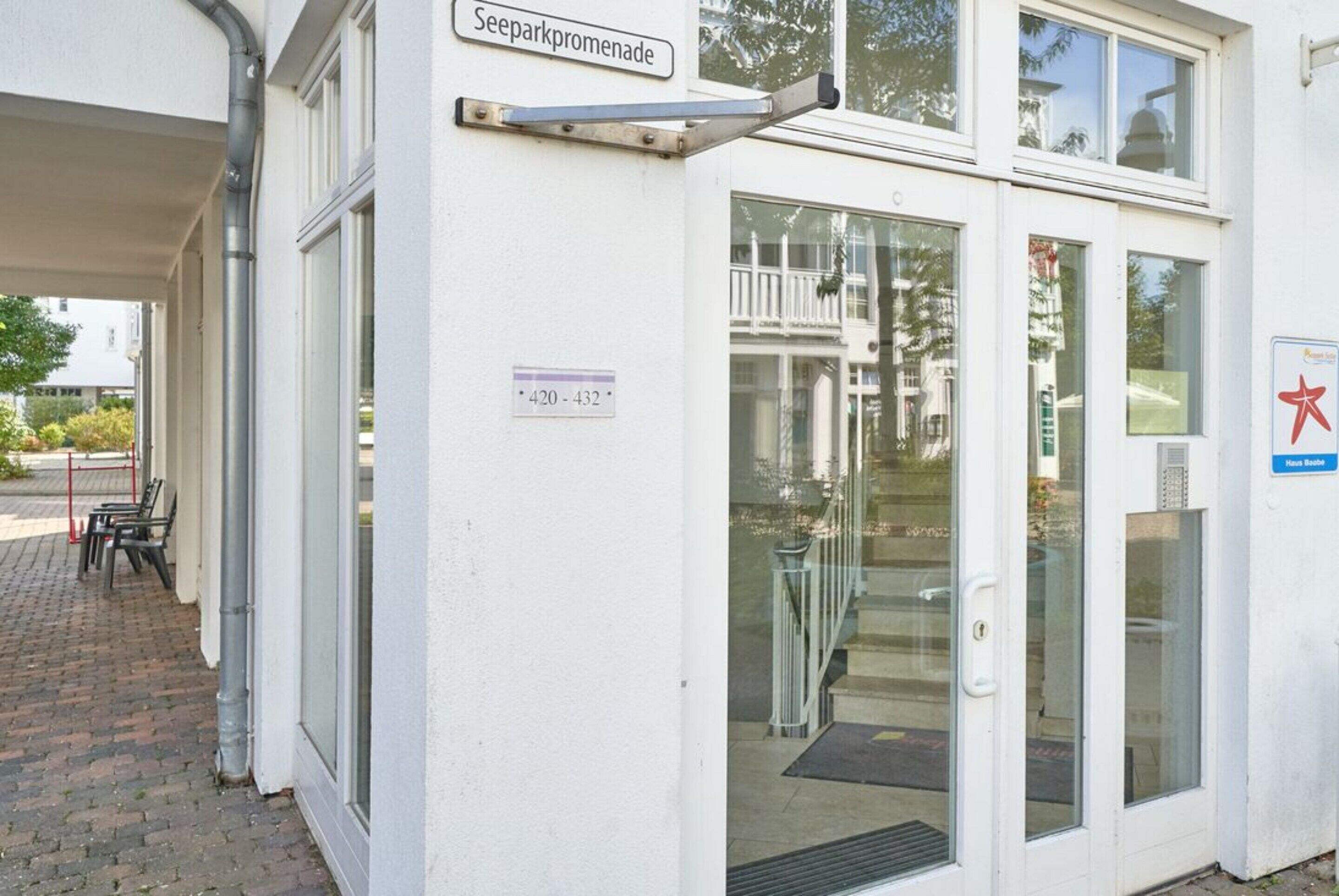 A building entrance with a sign reading 'Seeparkpromenade' and a door with a glass panel.
