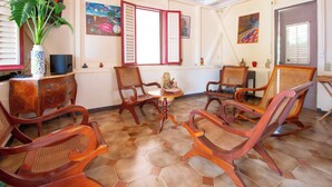 Ein Zimmer mit Holzmöbeln, Fliesenboden und Bildern an den Wänden.