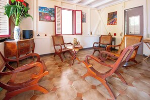 Ein Zimmer mit Holzmöbeln, Fliesenboden und Bildern an den Wänden.