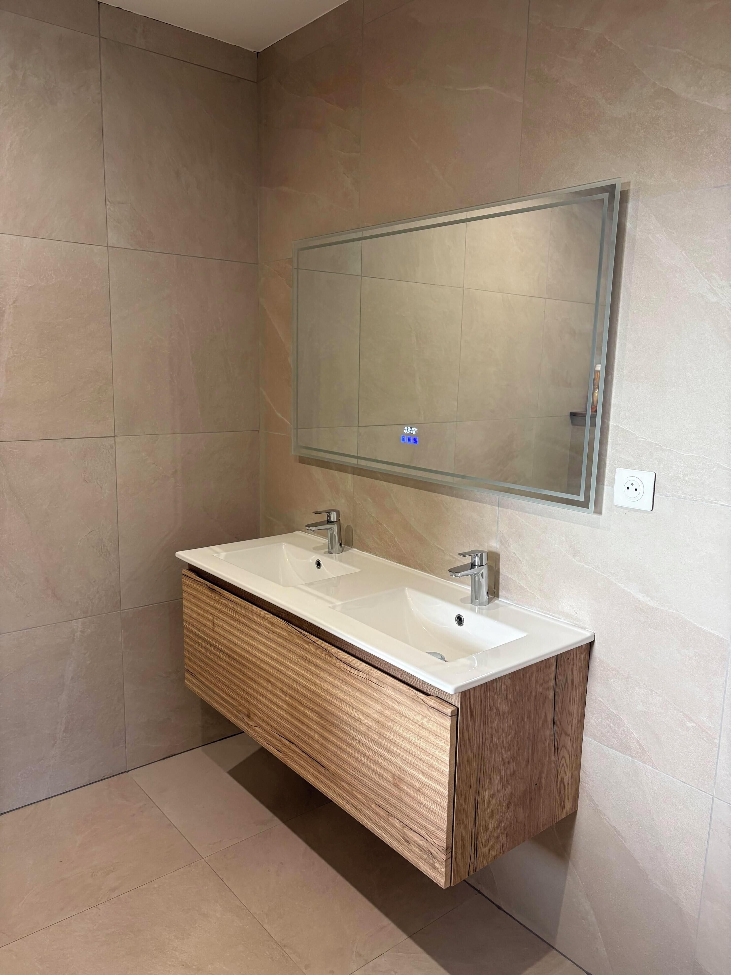 Un bagno con un mobile lavabo in legno, due lavabi e uno specchio grande.