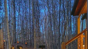 A forested area with a gravel path, wooden structures, and a signpost. - Level 2 EV charger~Quiet~clean~cozy~fast WIFI~Dollywood~fireplace~hotub #11 (Sevierville)