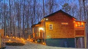 A wooden cabin with a porch, a welcome sign, and a window. - Level 2 EV charger~Quiet~clean~cozy~fast WIFI~Dollywood~fireplace~hotub #11 (Sevierville)
