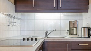 A modern kitchen with a stainless steel sink, a coffee maker, and dark wooden cabinets. - Attraktive Ferienwohnung fur 4 mit Balkon und Wlan in Sellin (Sellin)