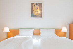 A hotel room with a large bed, two bedside lamps, and a framed artwork on the wall. - Ostseeurlaub - Stilvolle Ferienwohnung mit Balkon in Sellin (Sellin)
