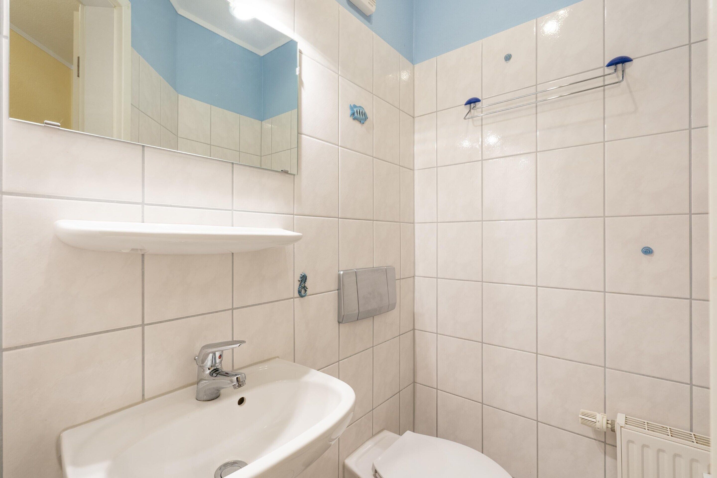 Un baño con lavabo, espejo, ducha e inodoro.