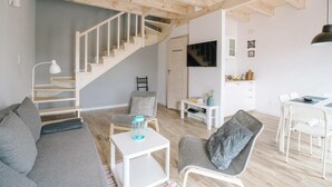 A modern living room with a staircase, a dining area, and a kitchen. - Holiday Home With Terrace, Large Garden (Choczewo)