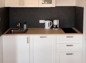 A kitchen with a sink, a kettle, a coffee maker, and a countertop. - Holiday Home With Terrace, Large Garden (Choczewo)
