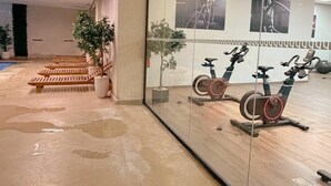 Een fitnessruimte met hometrainers, een muur met motivatieposters en een kamerplant.