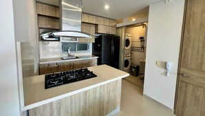 Una cocina moderna con una isla central, electrodomésticos de acero inoxidable y armarios de madera.