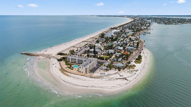 An aerial view of a coastal resort with a beach, a pool, and a marina. - Turquoise Dream  One bedroom Condo On Pass a Grille Beach (St. Pete Beach)