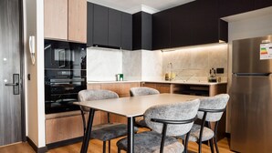Una cucina moderna con forno integrato, microonde e frigorifero in acciaio inossidabile.