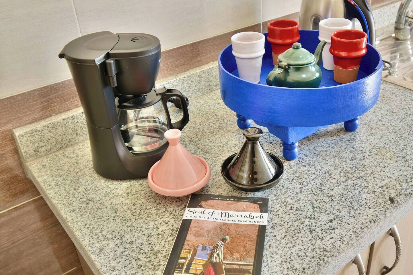 Keittiön työtasolla on kahvinkeitin, vedenpuhdistin, mausteteline ja matkaopas.