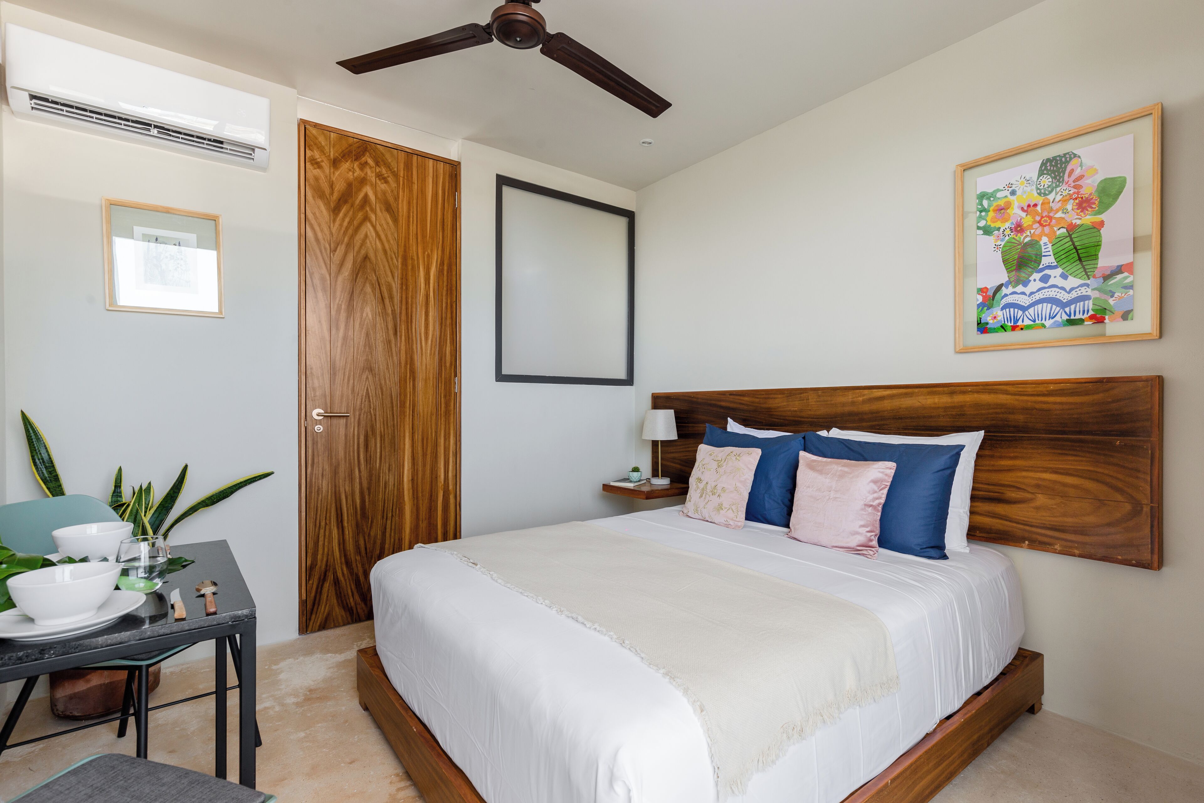 A bedroom with a bed, bedside table, and a ceiling fan.