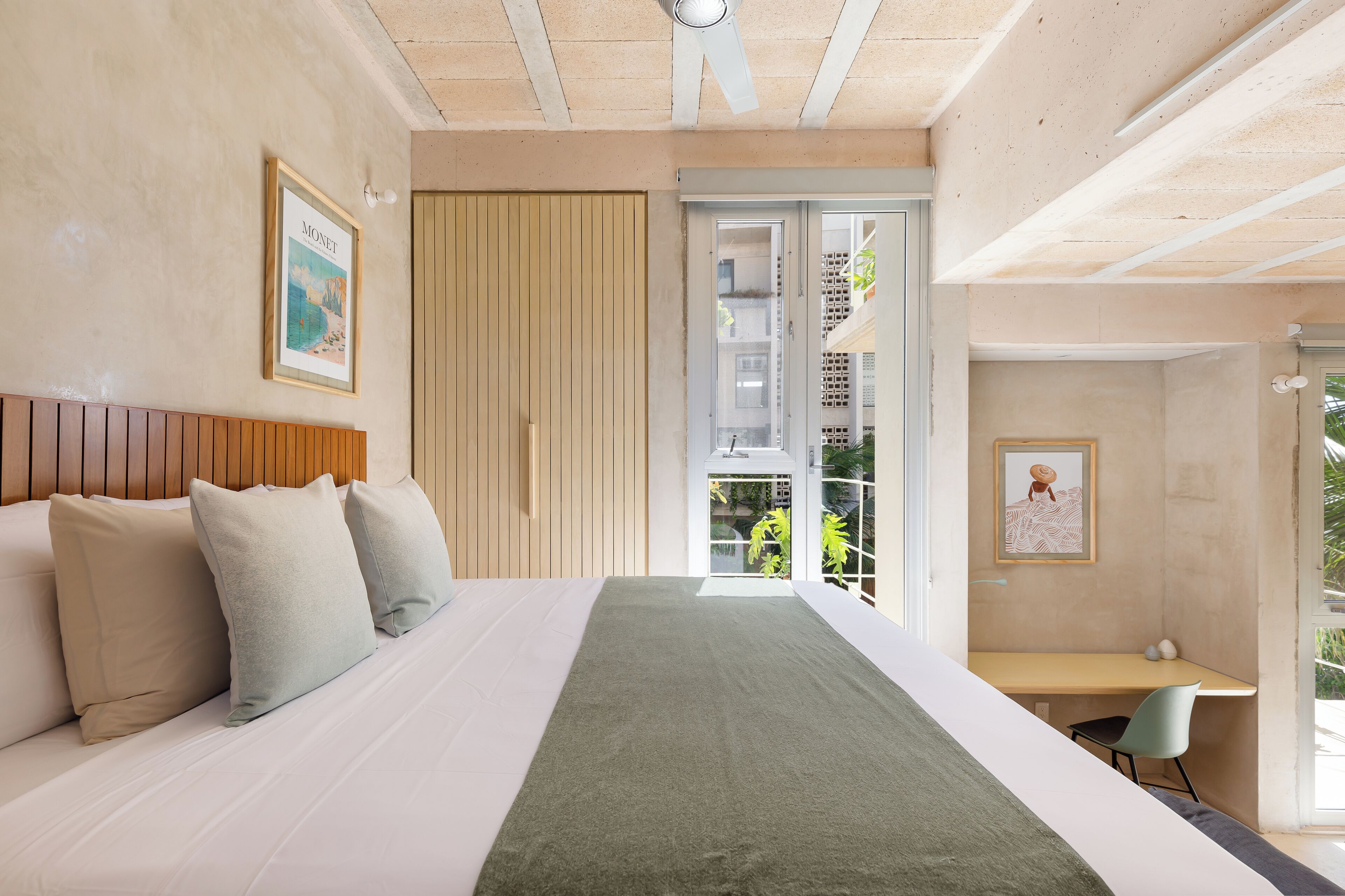 Een moderne slaapkamer met een bed, een bureau en uitzicht op buiten.